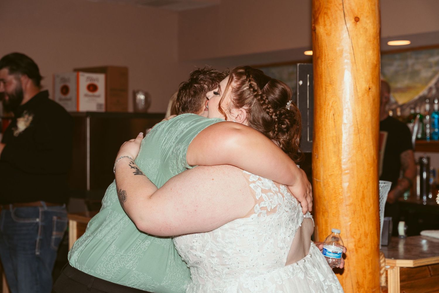 Emotional moment captured as two people share a heartfelt embrace at a wedding reception.