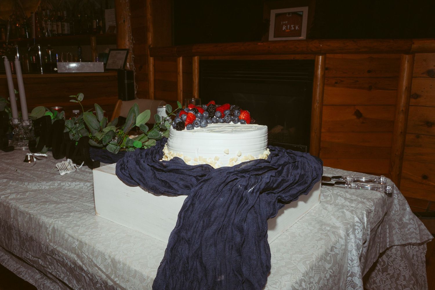 A navy blue garment lies crumpled on a white surface in a dimly lit wooden room.