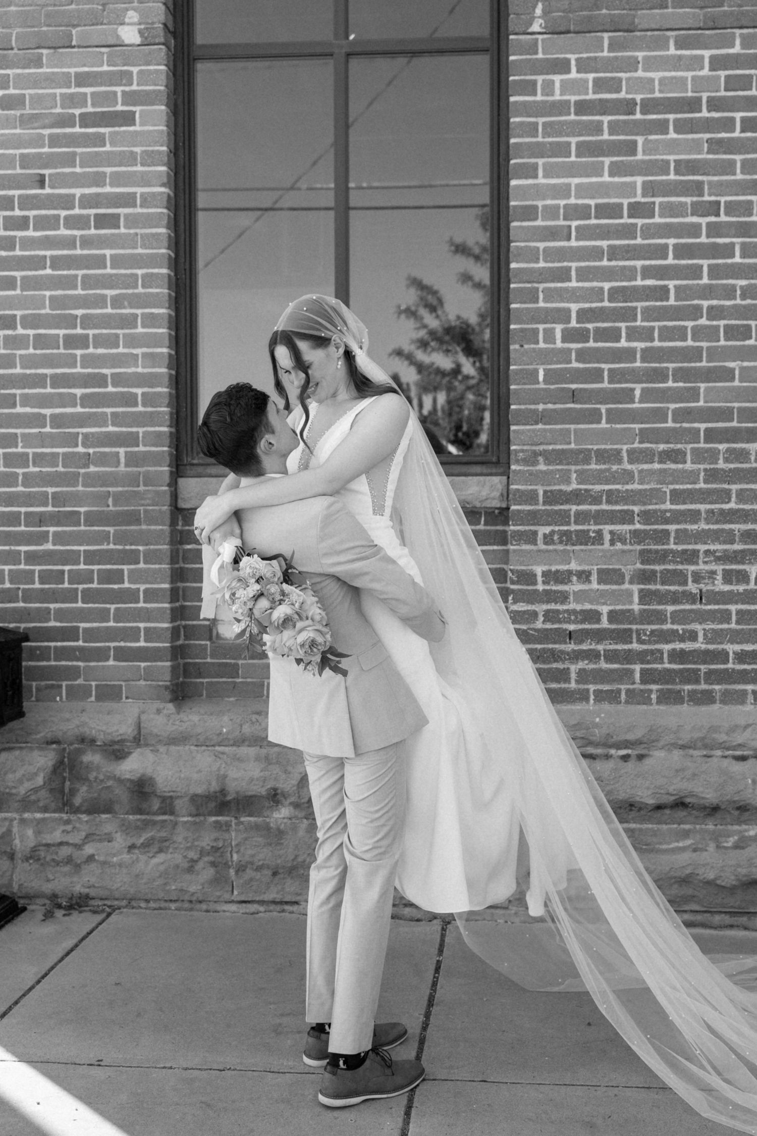 Wedding sequence showing romantic dance-like poses against brick wall backdrop.