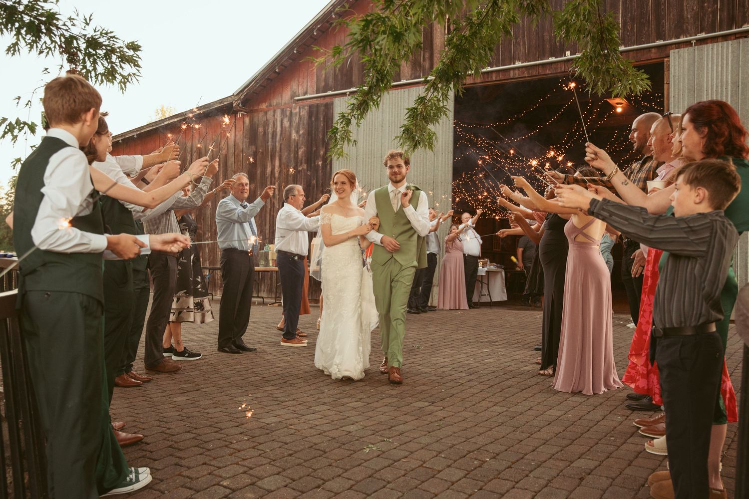 Wedding celebration in a rustic barn venue decorated with string lights and paper lanterns.