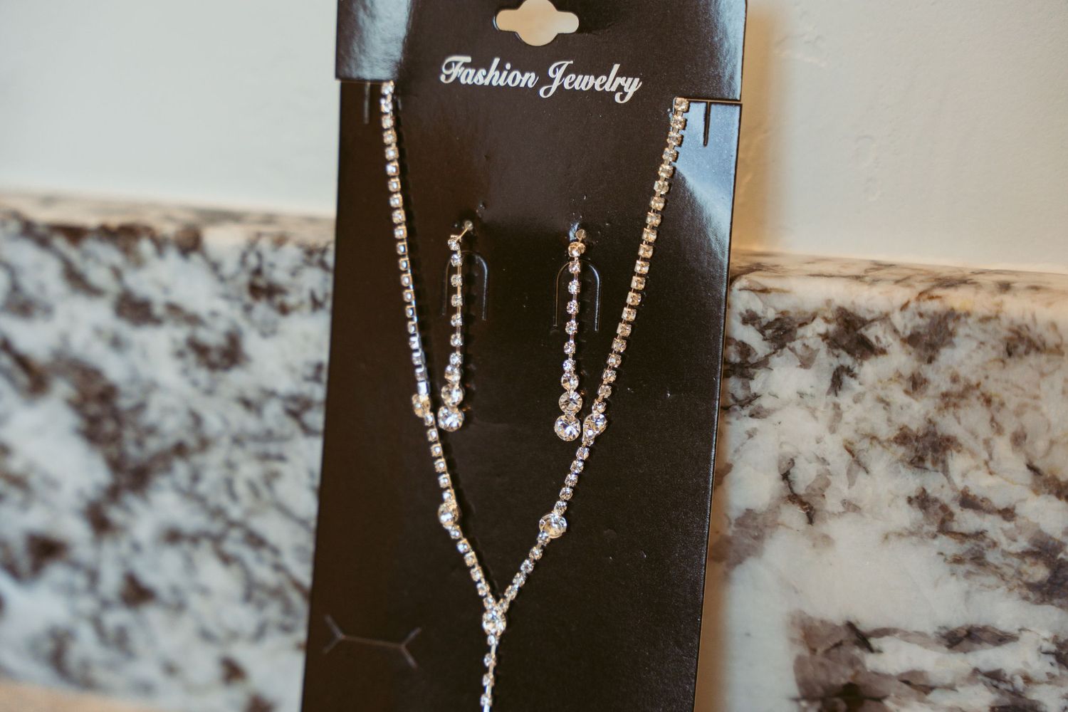 Fashion jewelry displayed on black cards showing delicate crystal designs.