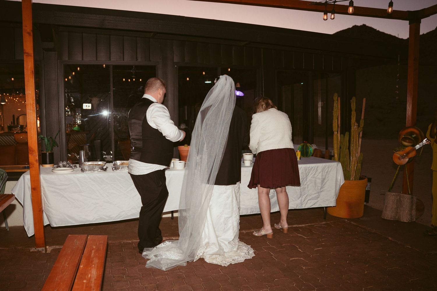 Wedding reception venue decorated with white linens and warm lighting for an evening celebration.