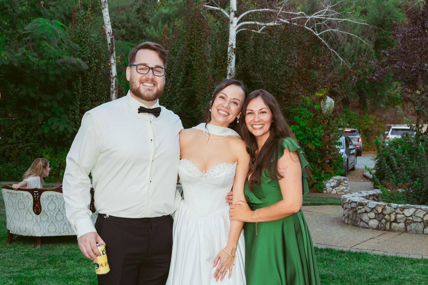Wedding celebration in lush garden setting with guests enjoying outdoor festivities.