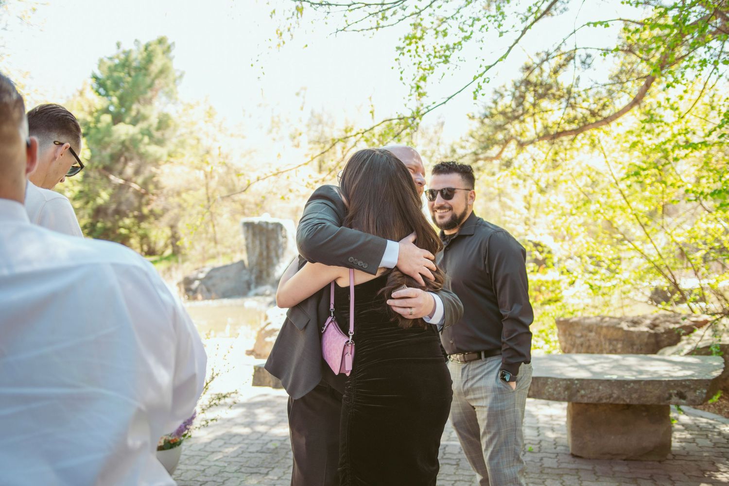 Friends sharing laughs and conversations in a casual outdoor setting surrounded by greenery.