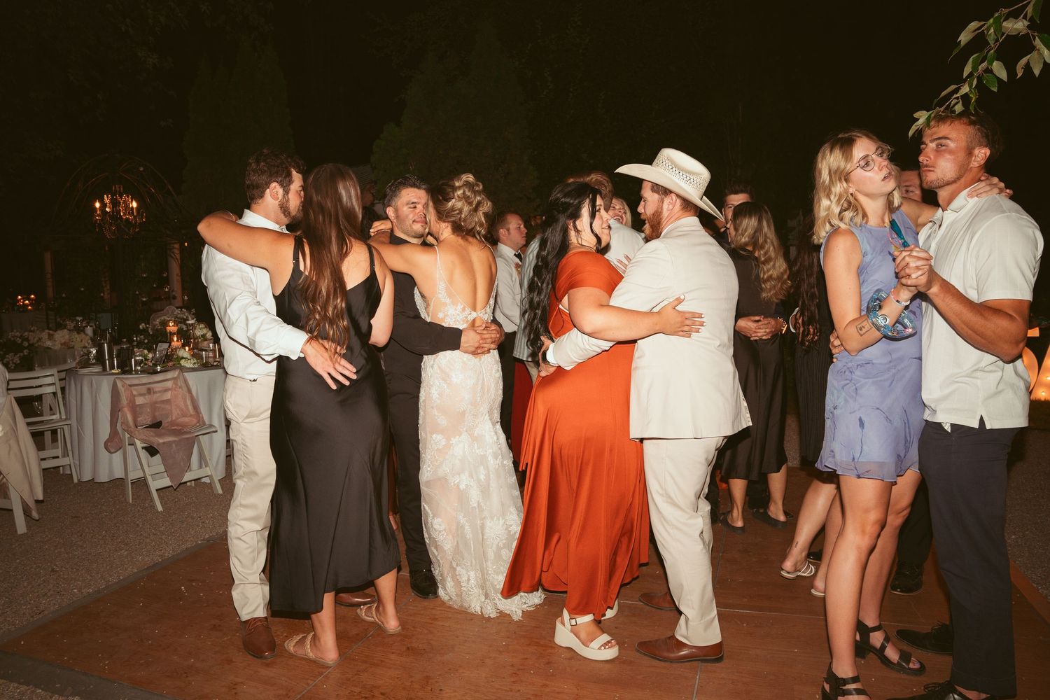 Couples dancing together at an outdoor wedding reception.