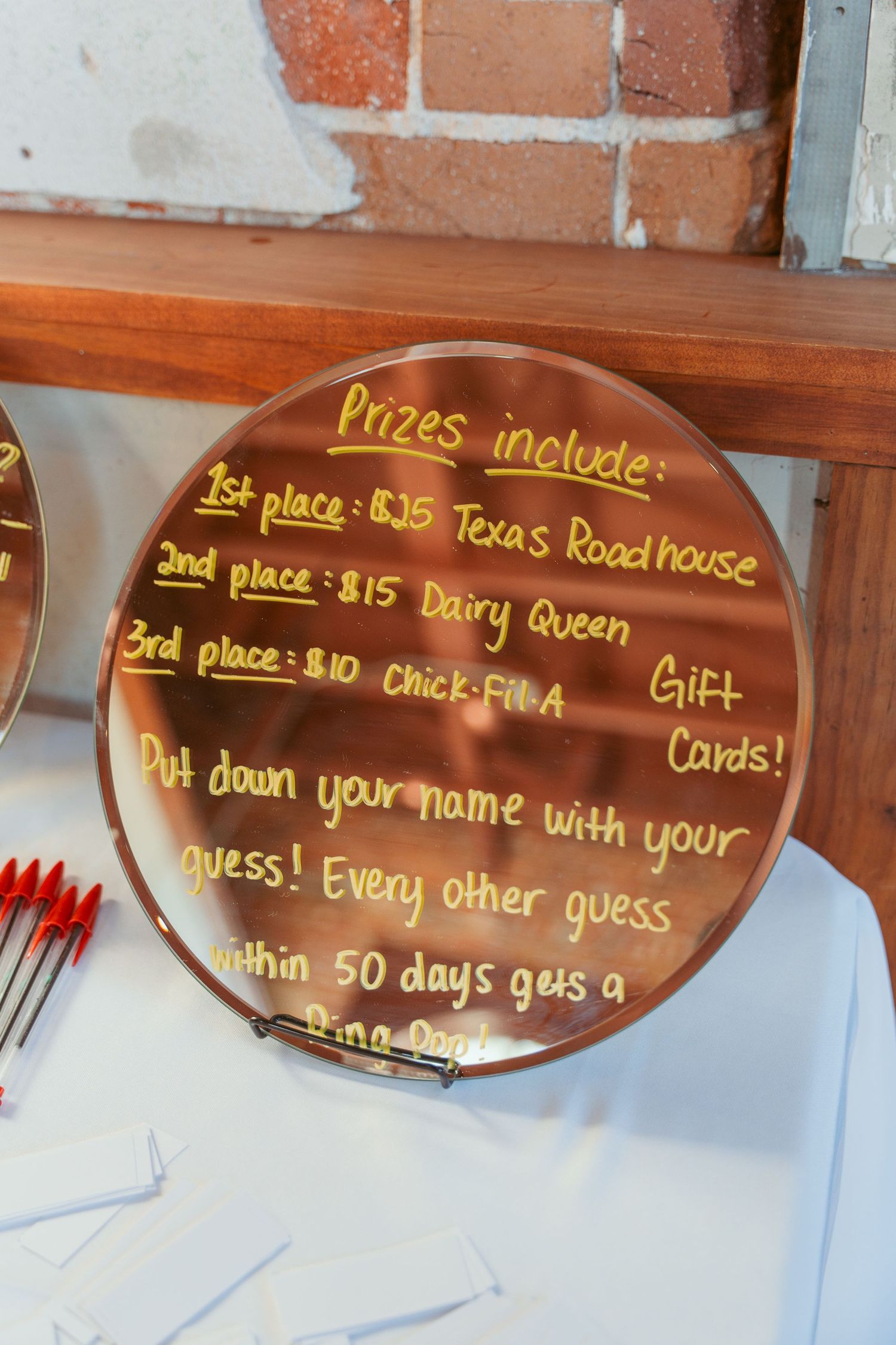 Brown mirror signs displaying prize information including gift cards for Dairy Queen and Texas Roadhouse.