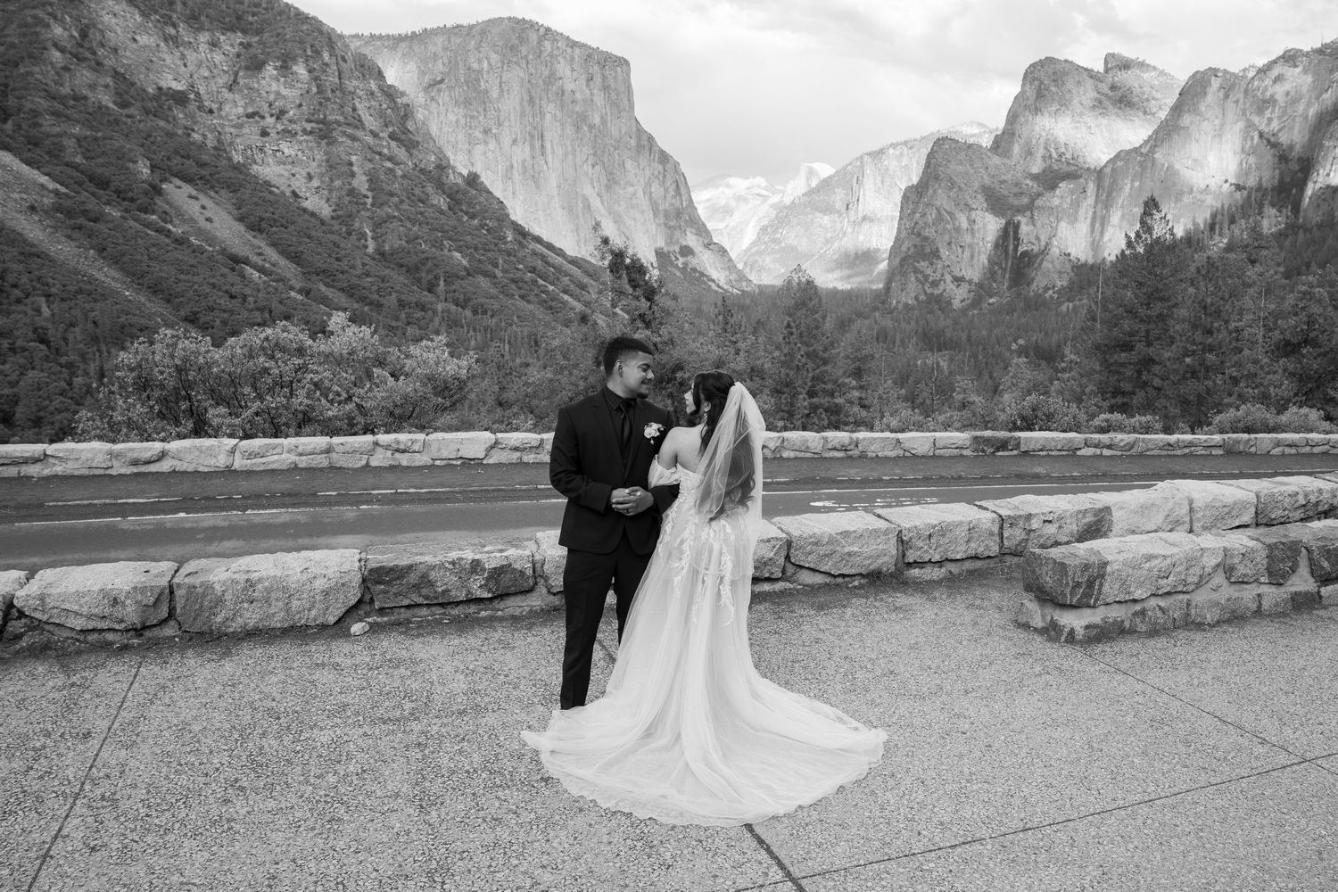 Black and white panorama of a wedding couple enjoying the vast Yosemite landscape.