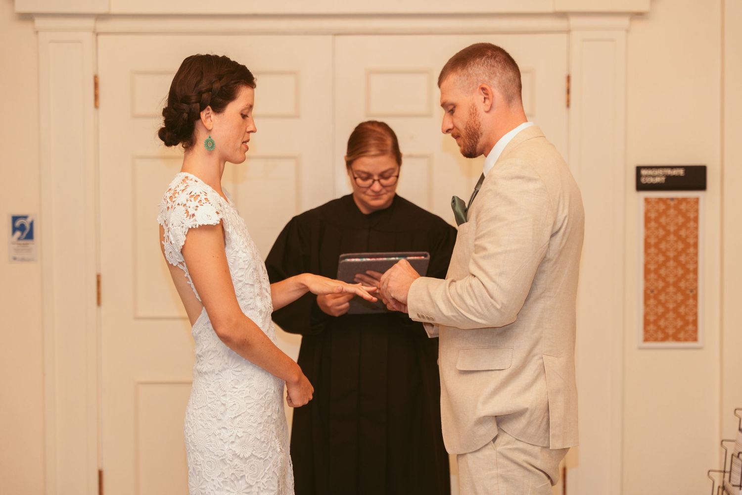 A wedding ceremony in progress inside a traditional room with white architectural details.