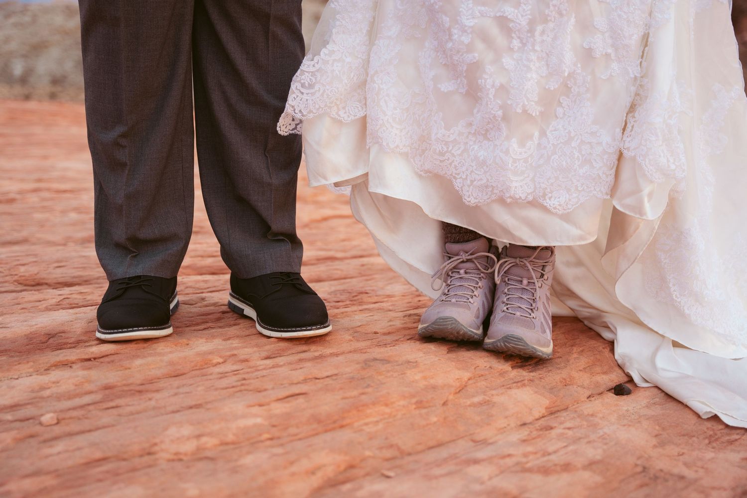Detail shot of wedding dress and formal shoes against red desert rock formations.