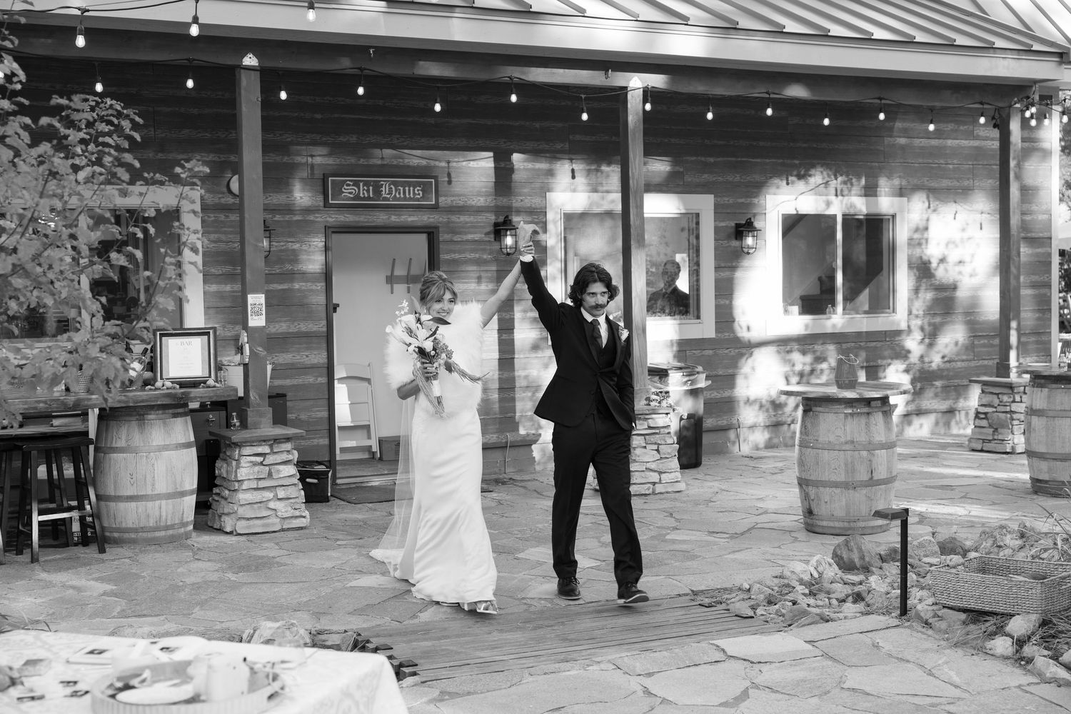 Wedding venue exterior with stone patio and rustic wooden architecture.