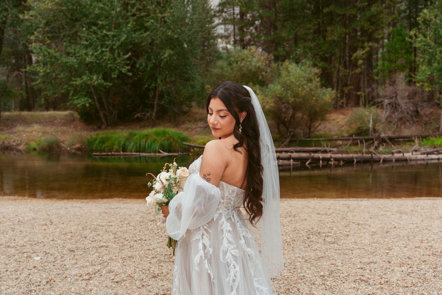 Scenic mountain lake wedding venue with bride in flowing white gown.