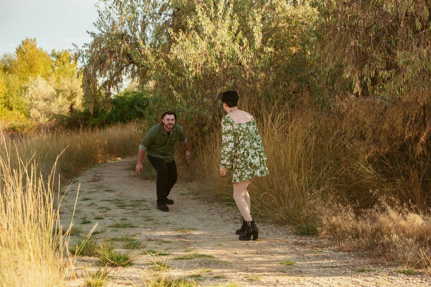 A couple shares a romantic dance moment on a dusty trail at sunset.