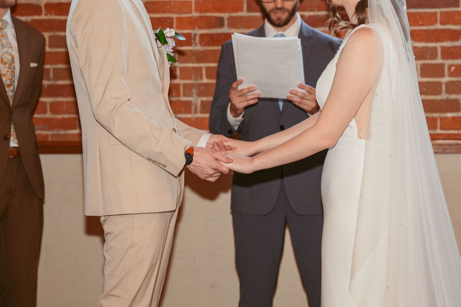 Wedding ceremony proceedings in an industrial-chic venue with exposed brick walls.