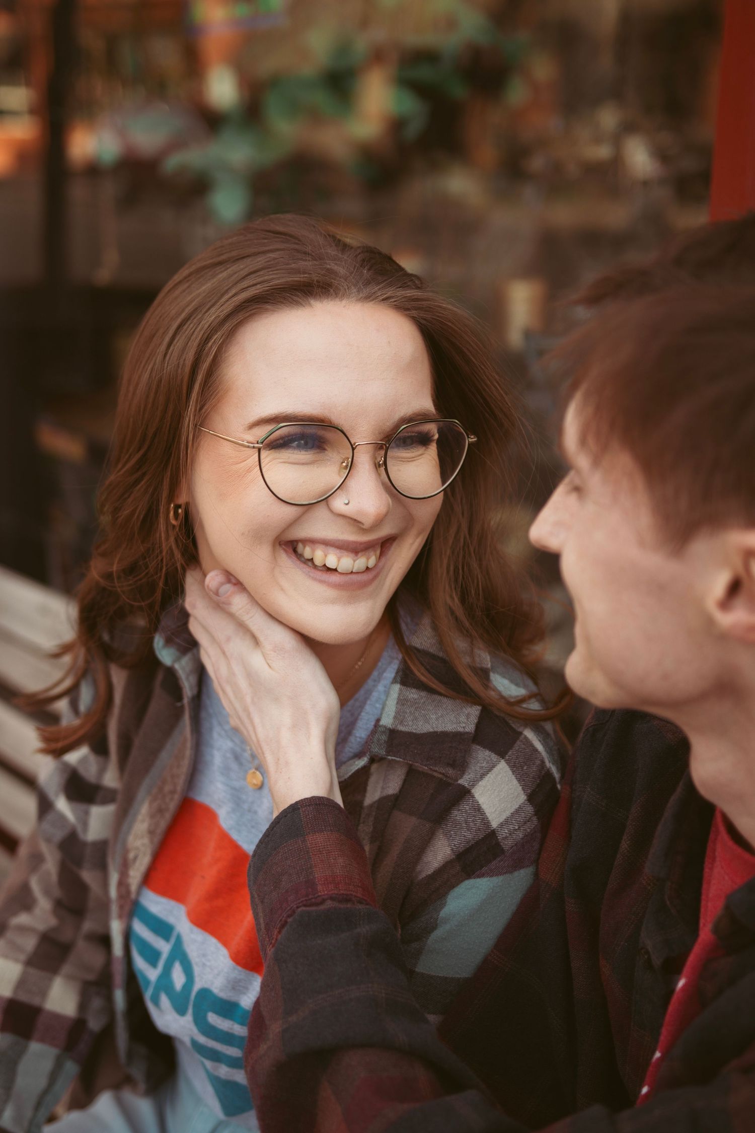A candid moment of laughter between two people wearing plaid shirts.