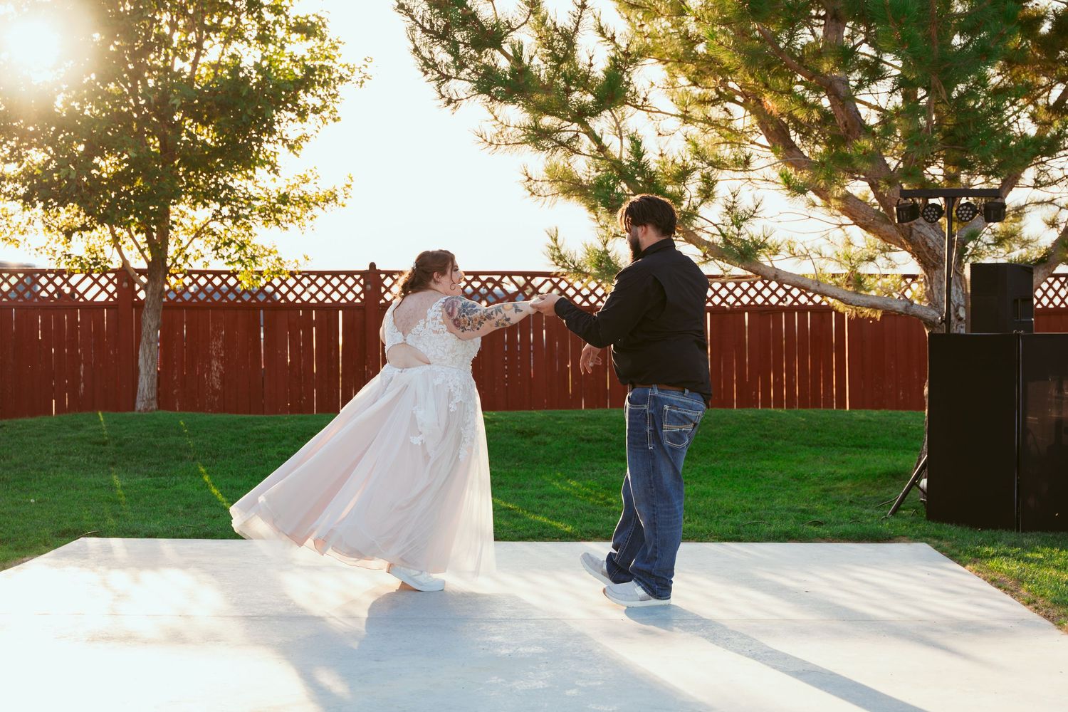 Wedding guests perform a synchronized dance routine outdoors at dusk.