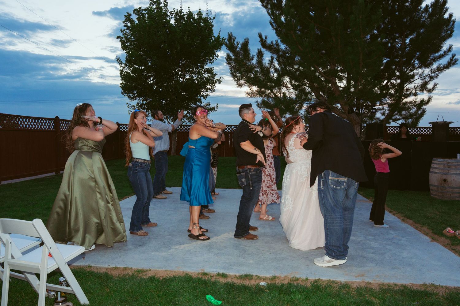 People gathered for an outdoor celebration with trees and blue sky in the background.