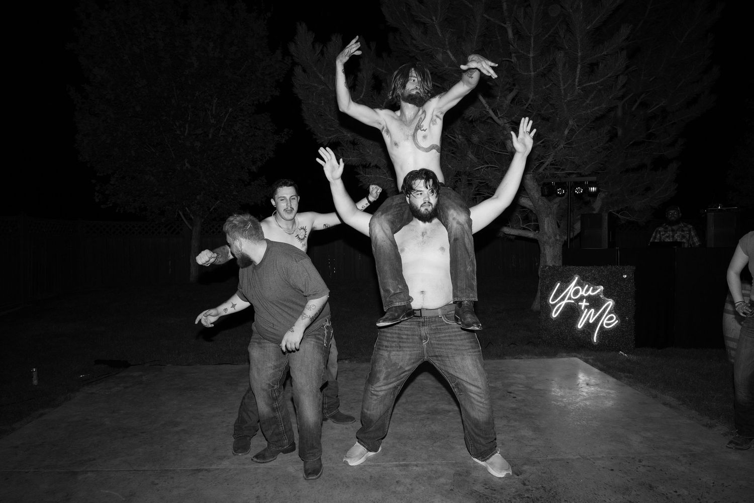 Black and white photo of people dancing enthusiastically at a party.