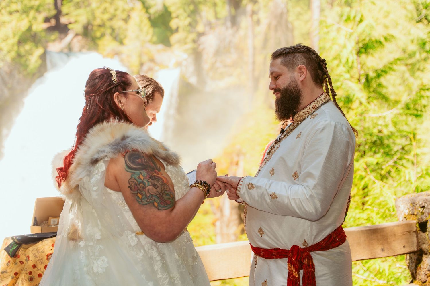 Wedding couple dances together in a serene forest setting with dappled sunlight.