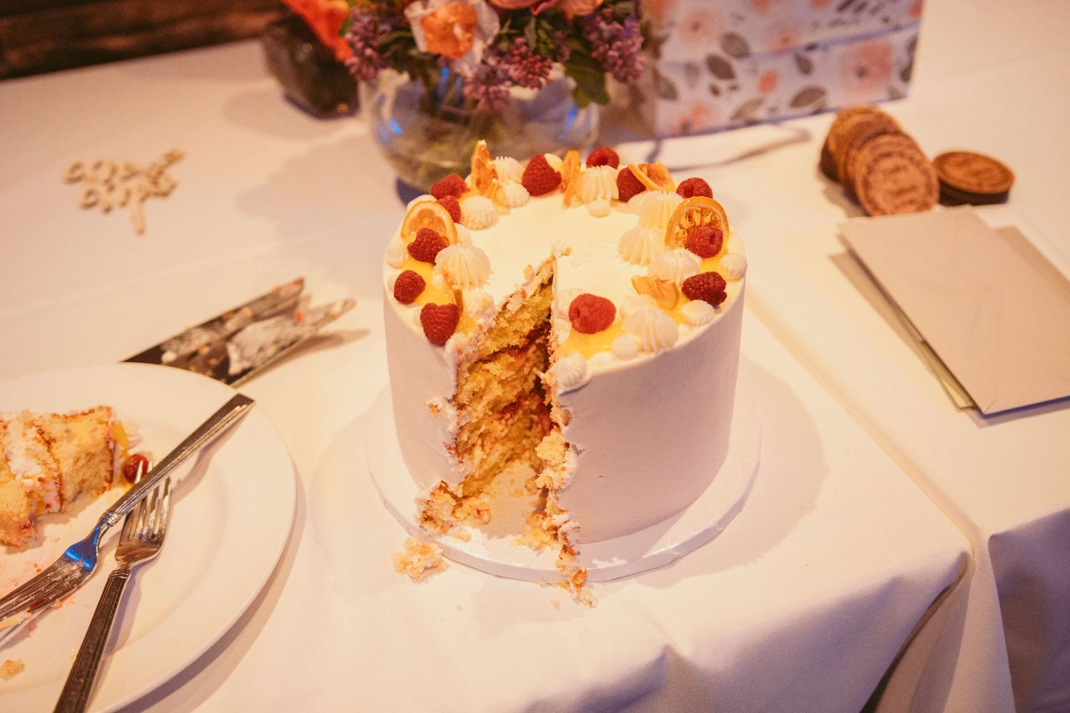 Close-up of partially eaten wedding cake slices on white tablecloths.