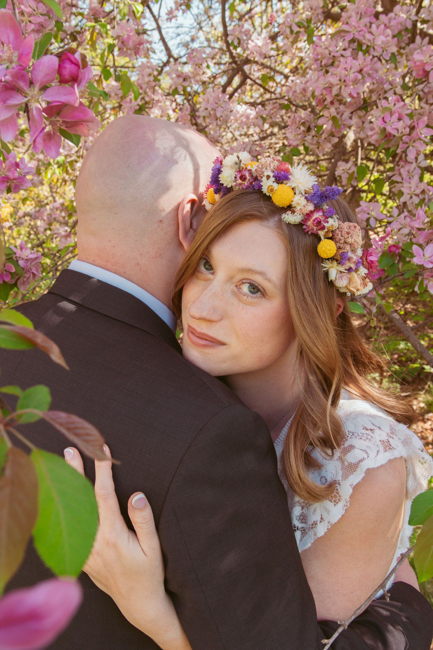 A romantic spring wedding portrait among blooming cherry blossoms and colorful flowers.