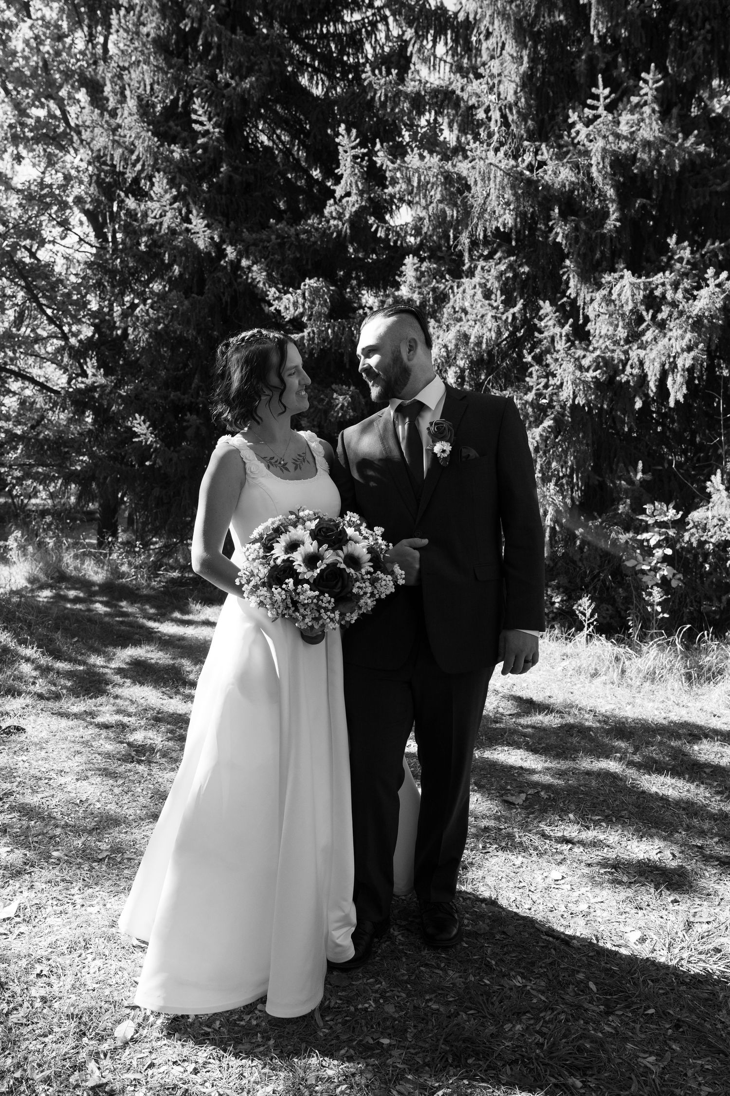 Black and white outdoor wedding portraits with natural wooded background.
