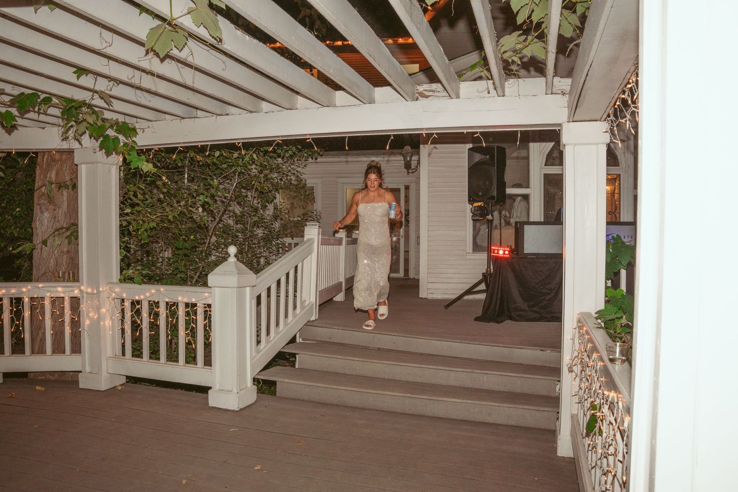 White pergola structure with columns decorated for an outdoor wedding venue.