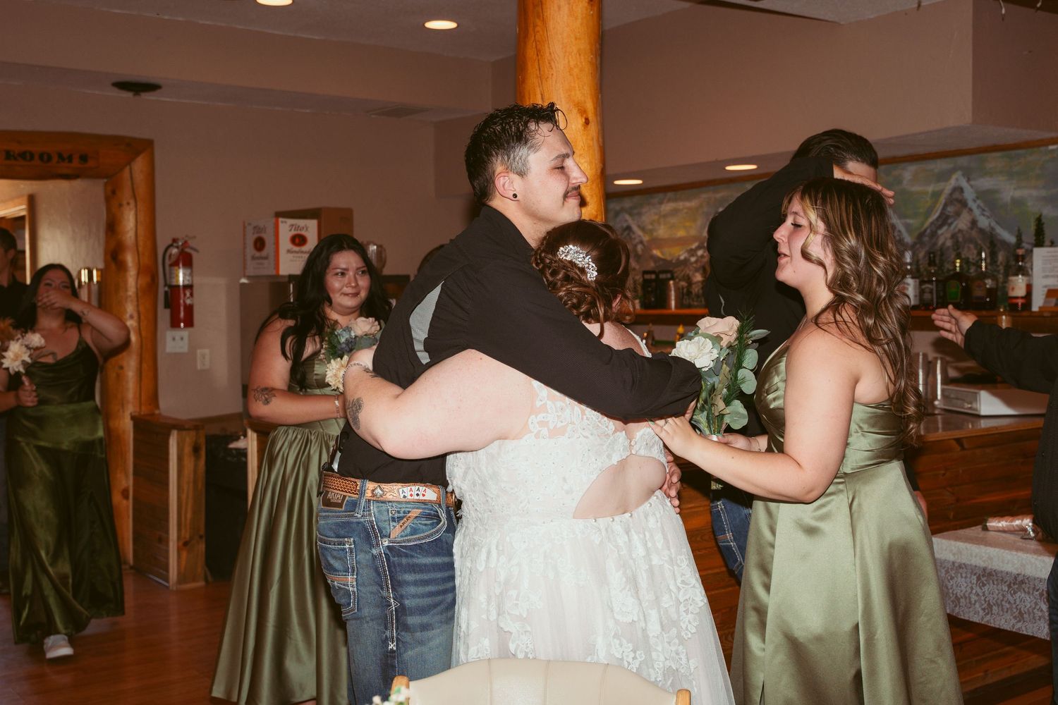 Couples dancing together at an indoor reception venue with warm lighting.