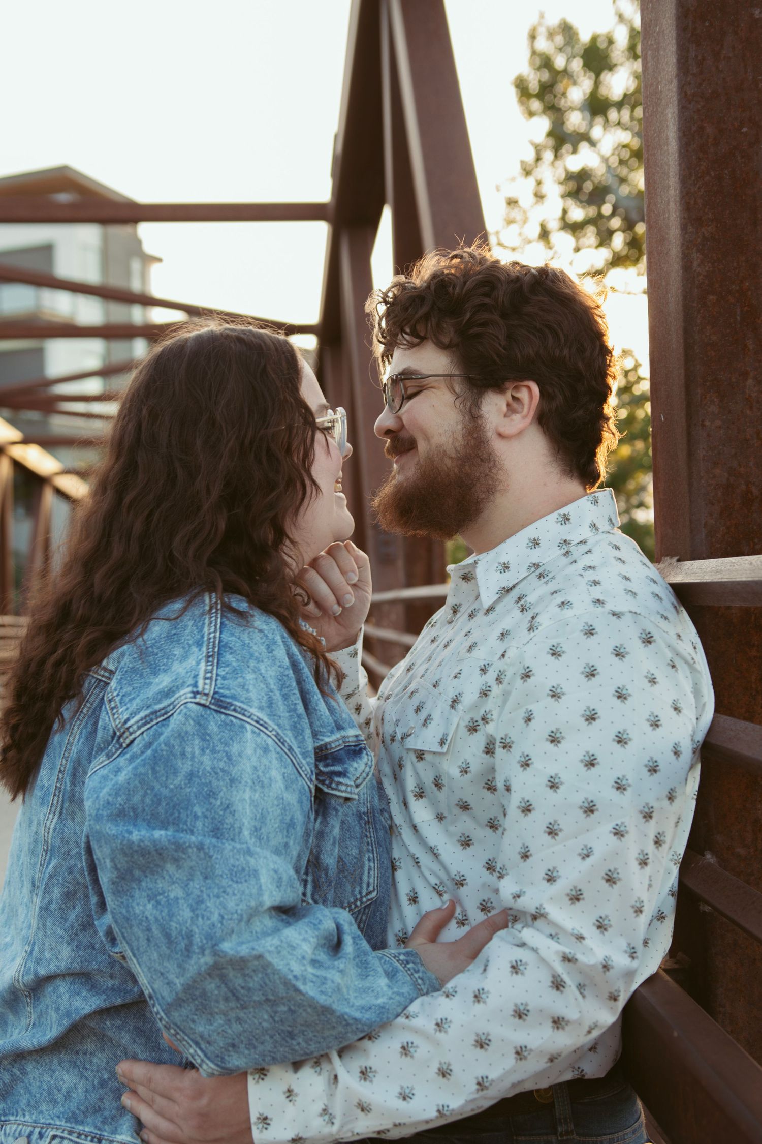 A tender embrace shared between two people on a wooden bridge.