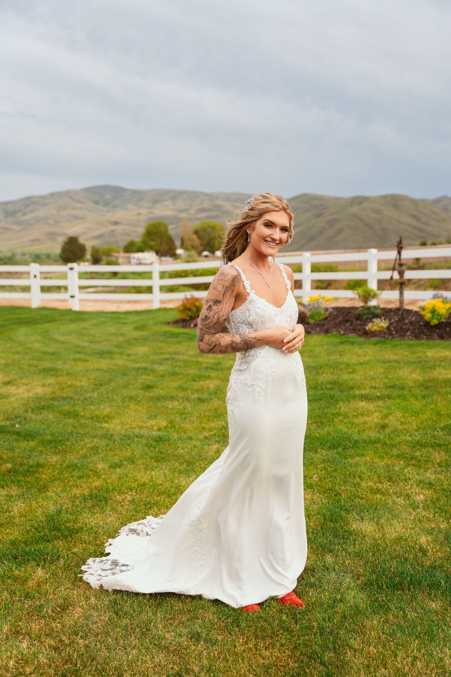 Bride spins joyfully in her wedding dress on a scenic lawn with mountain views.