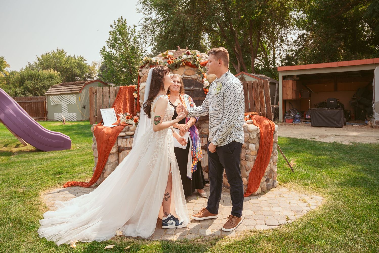 Wedding celebration photos taken in an outdoor garden setting with stone walls and decorative elements.