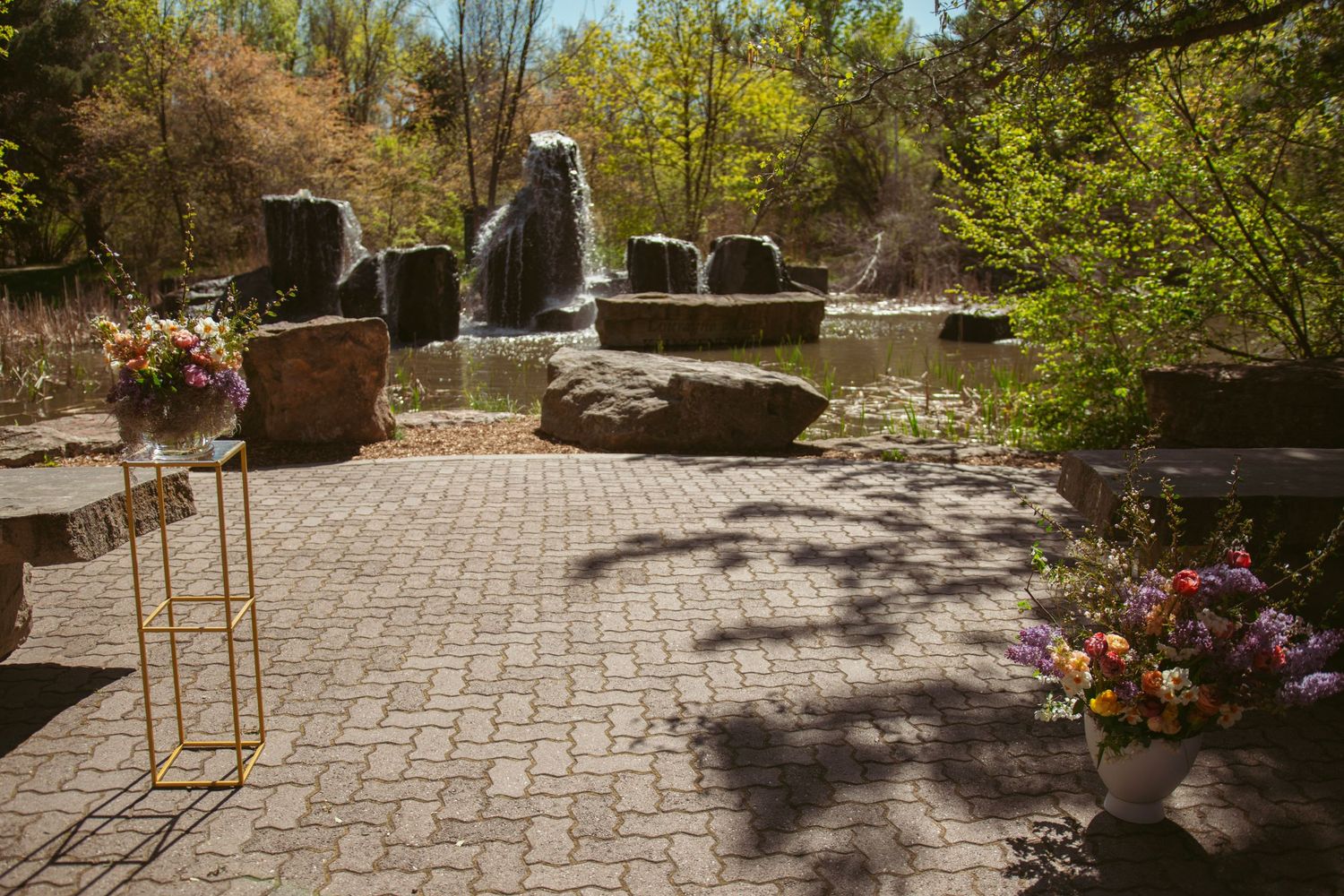 Stone pathway winding through a garden with trees and landscaping.