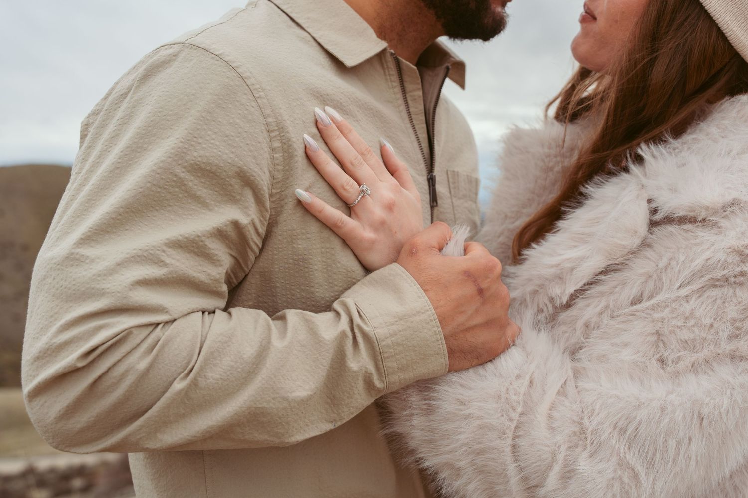 Close up shot of a couple in neutral tones sharing a tender embrace.