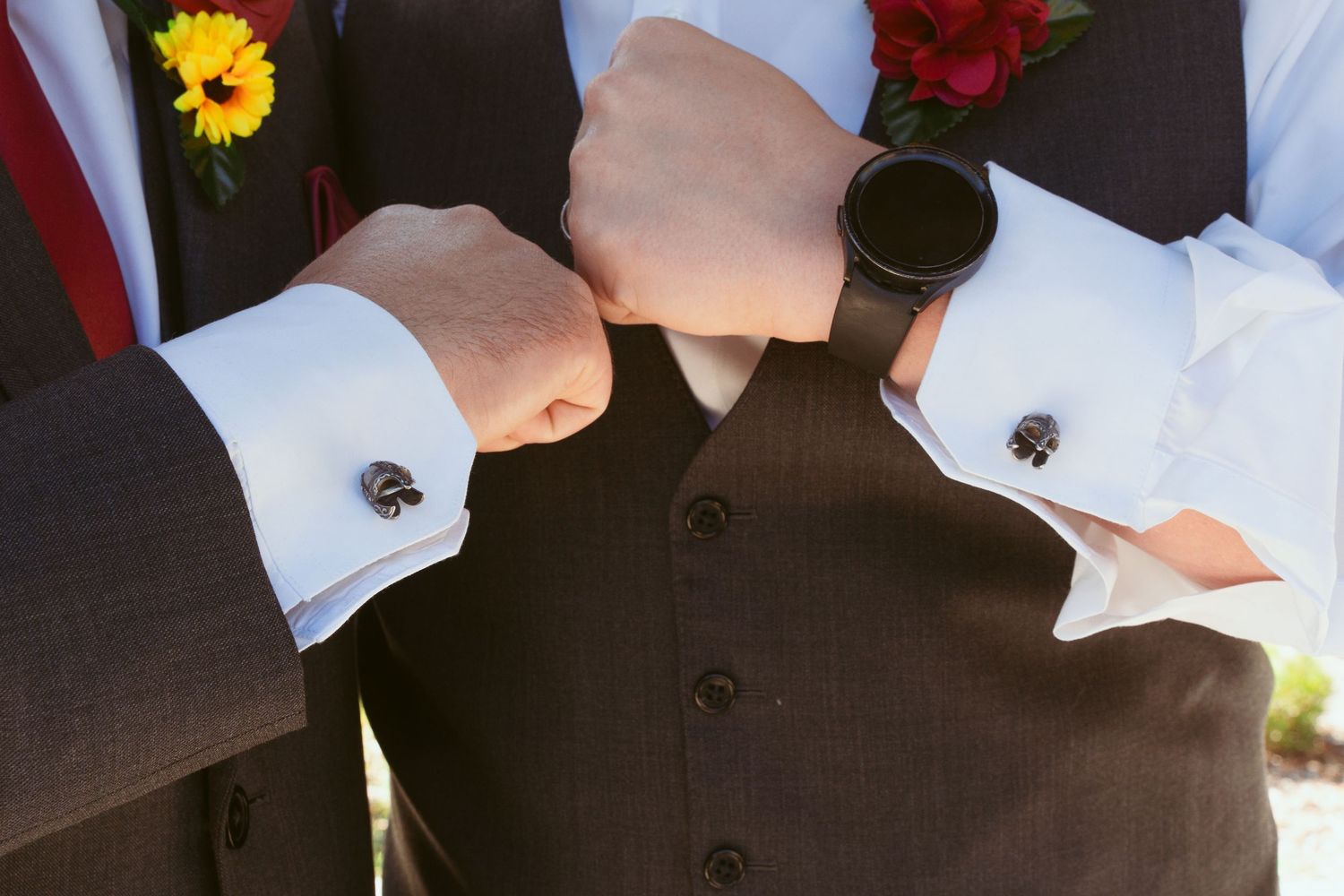 Wedding party attire detail showing black suits with yellow and red floral boutonnieres.