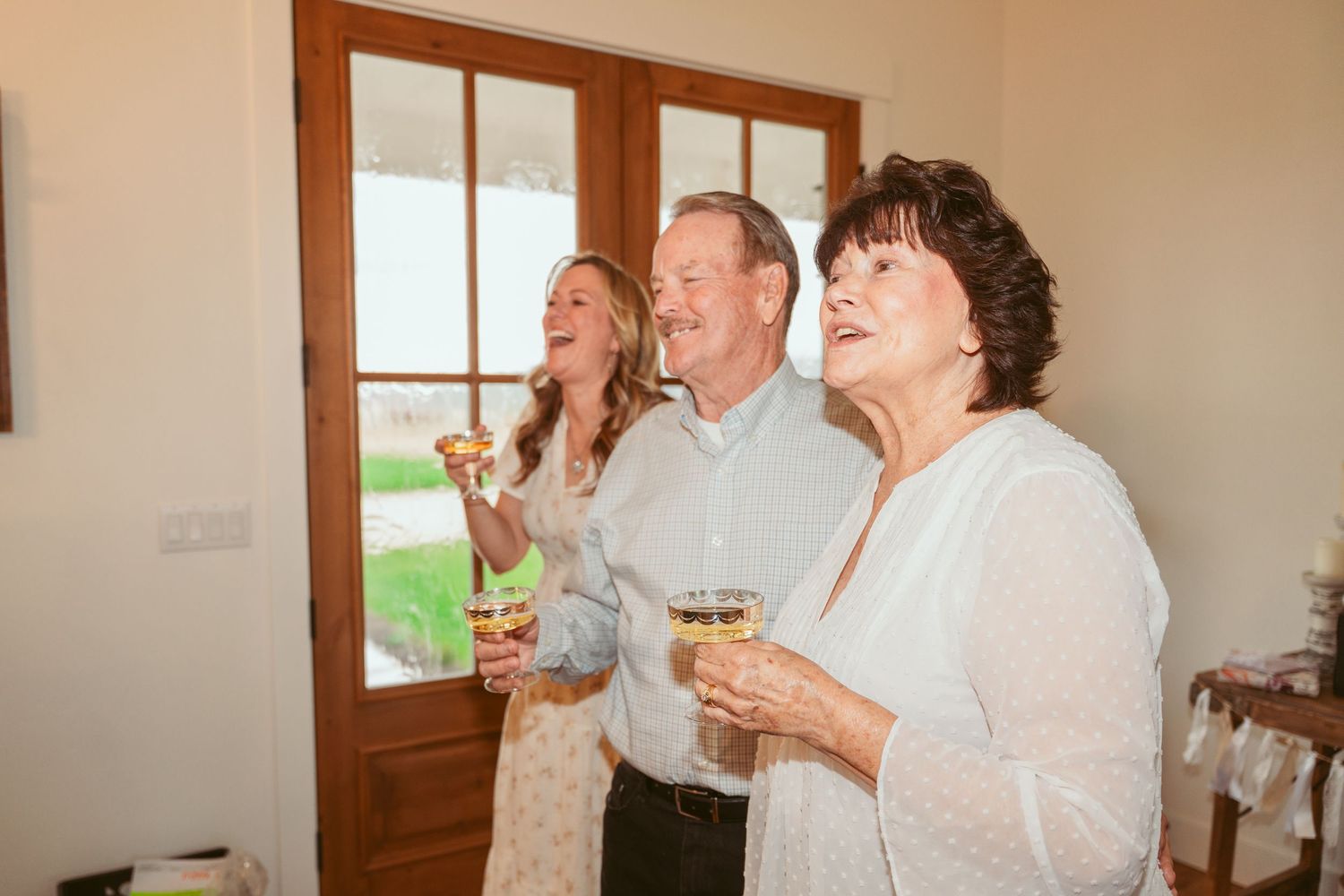 Wedding guests raise glasses in a celebratory toast during an indoor reception.