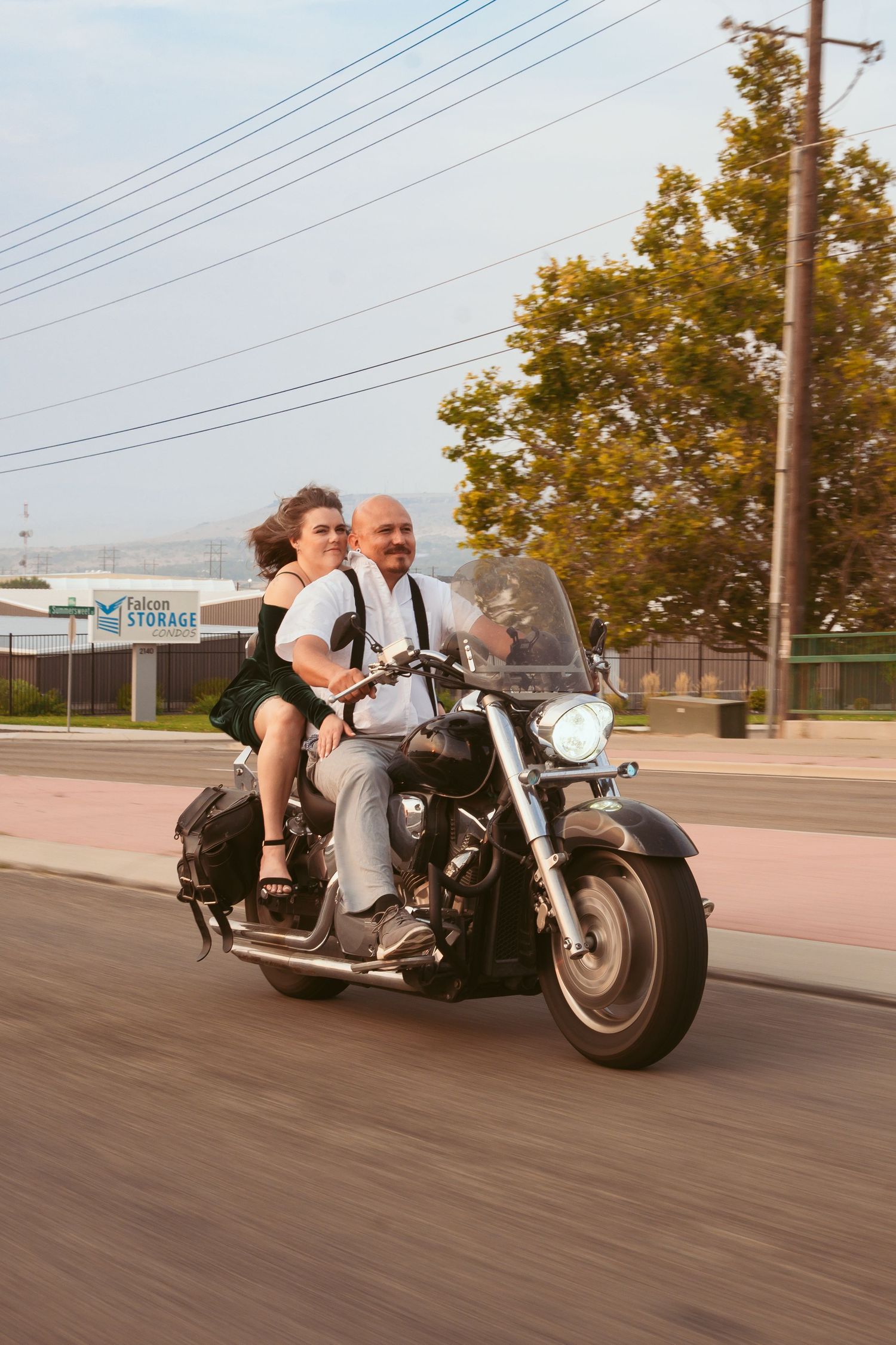 A motorcycle cruising down a suburban street with power lines visible in the background.