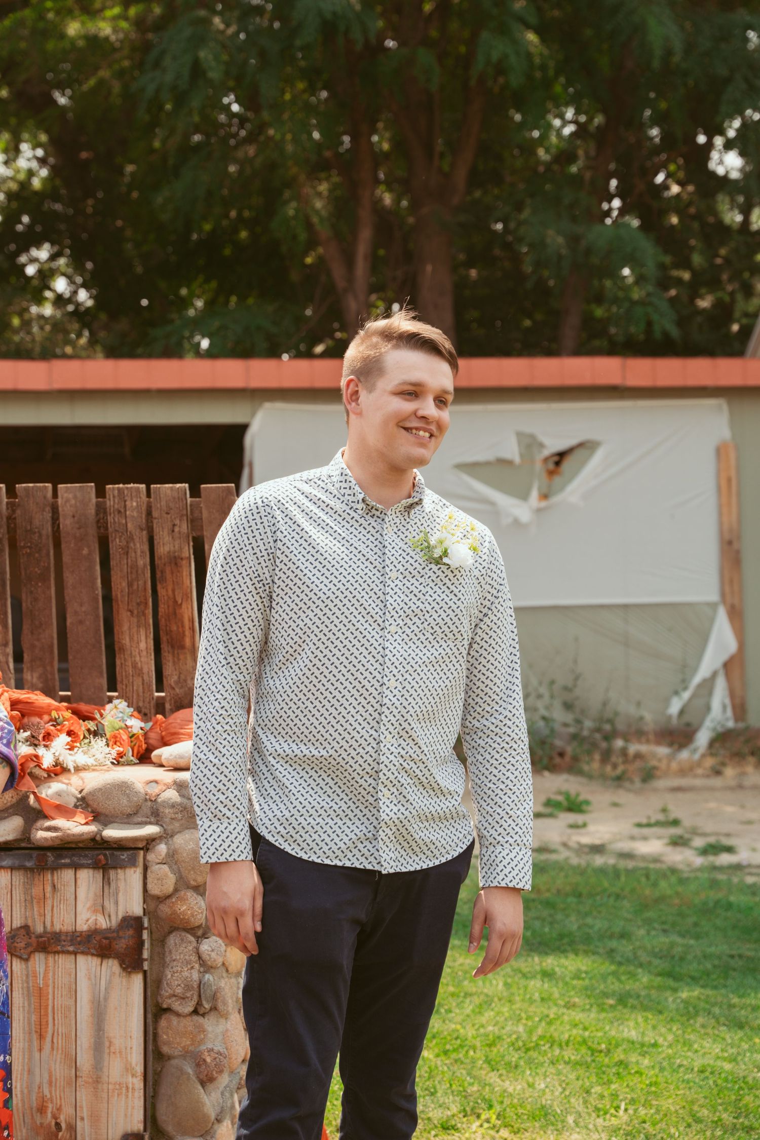 A romantic outdoor photo session in front of a rustic wooden fence with autumn decorations.