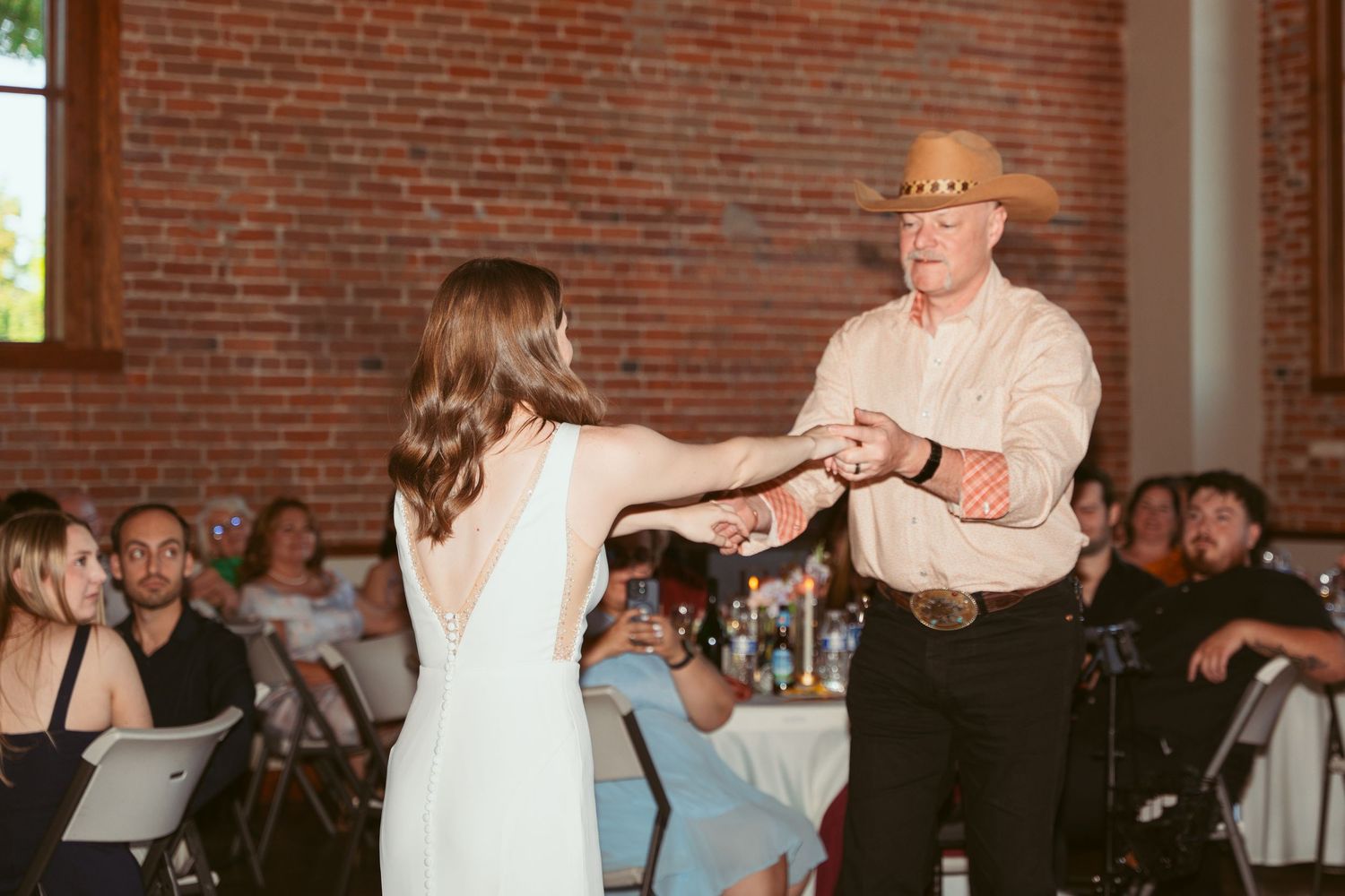 Dance partners perform a coordinated spin move during a wedding celebration.