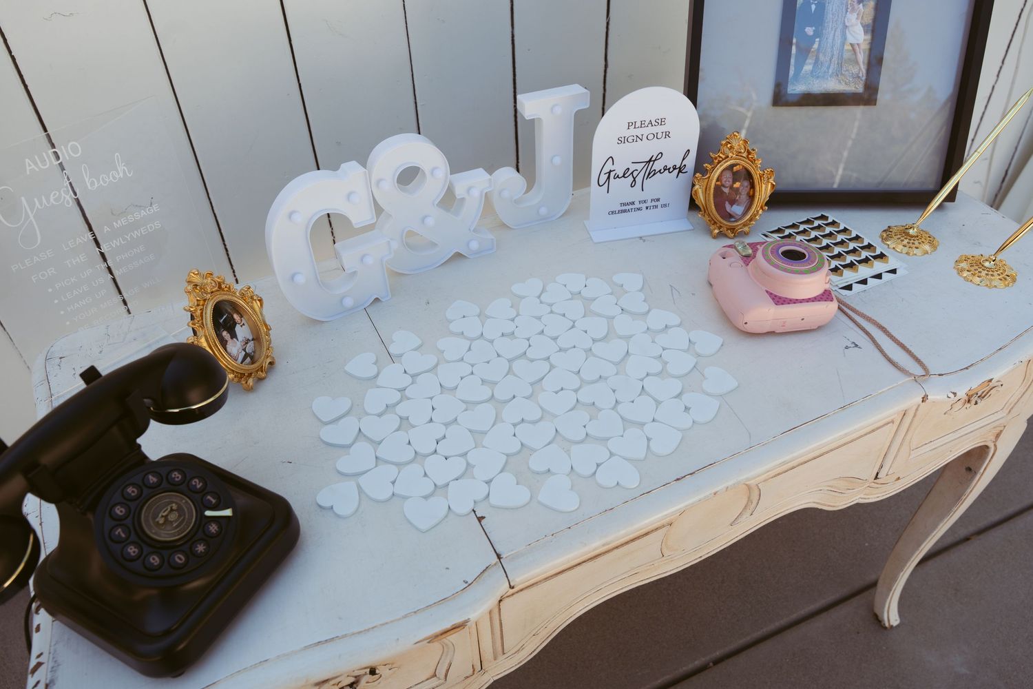 Wedding reception table setup with glassware and place settings on white tablecloths.