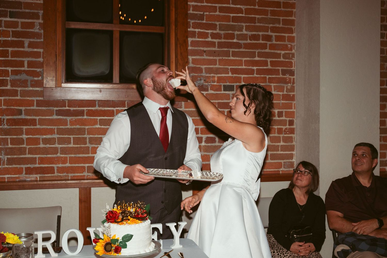 Celebration in progress at a rustic brick venue with string lights and dancing guests.