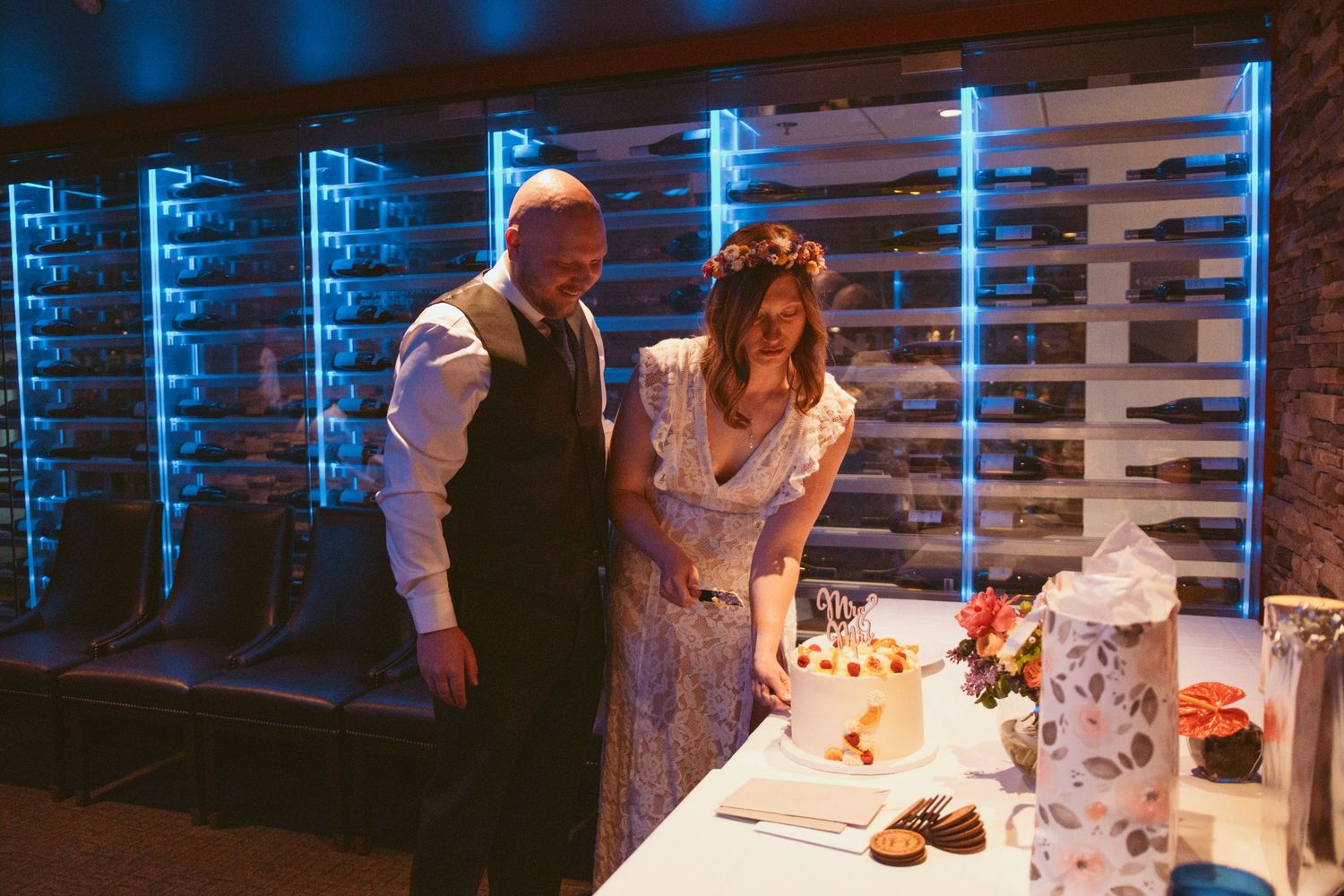 Couples dancing in a dimly lit venue with blue lighting and decorative white elements.