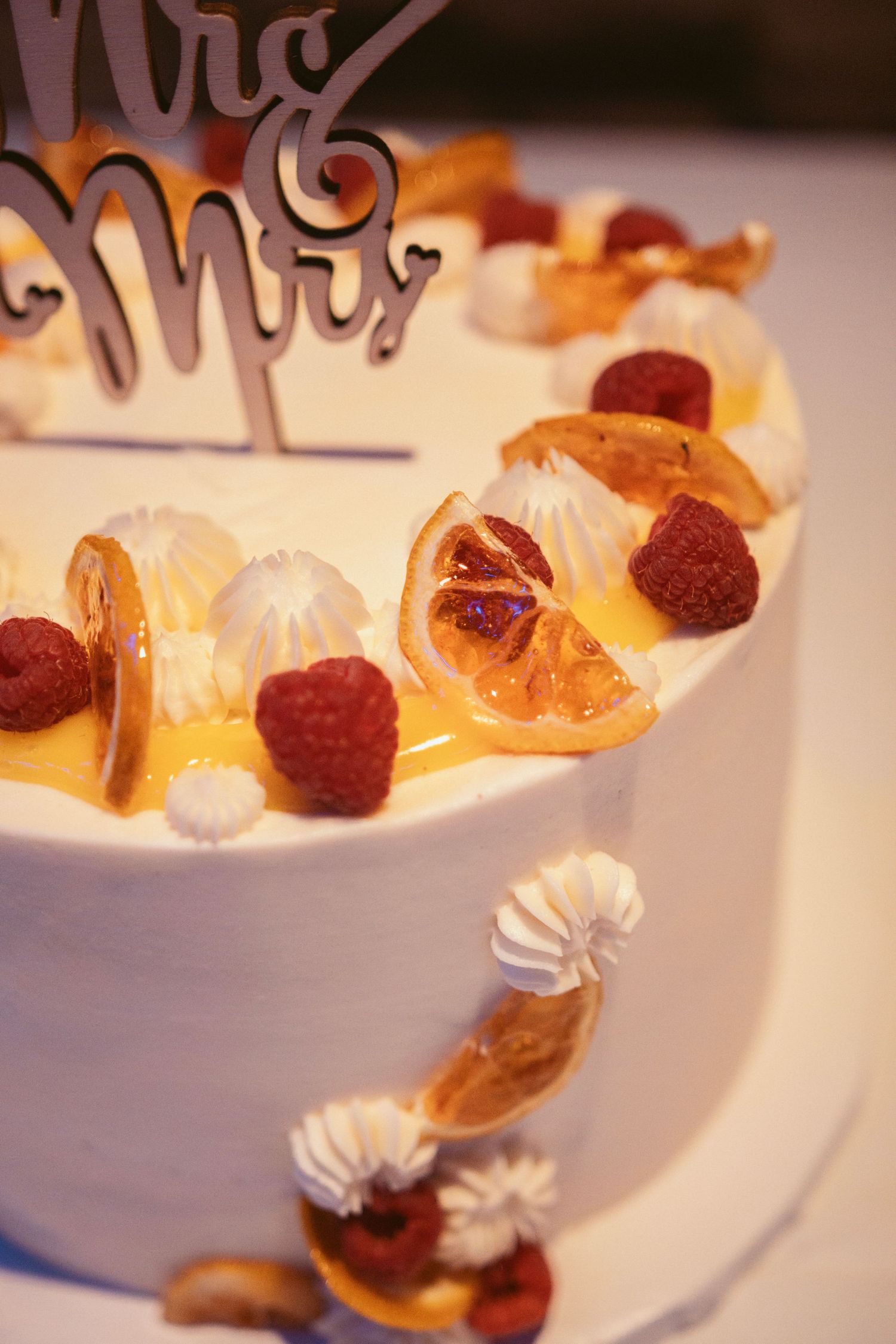 Elegant white wedding cake decorated with fresh fruit and berries.