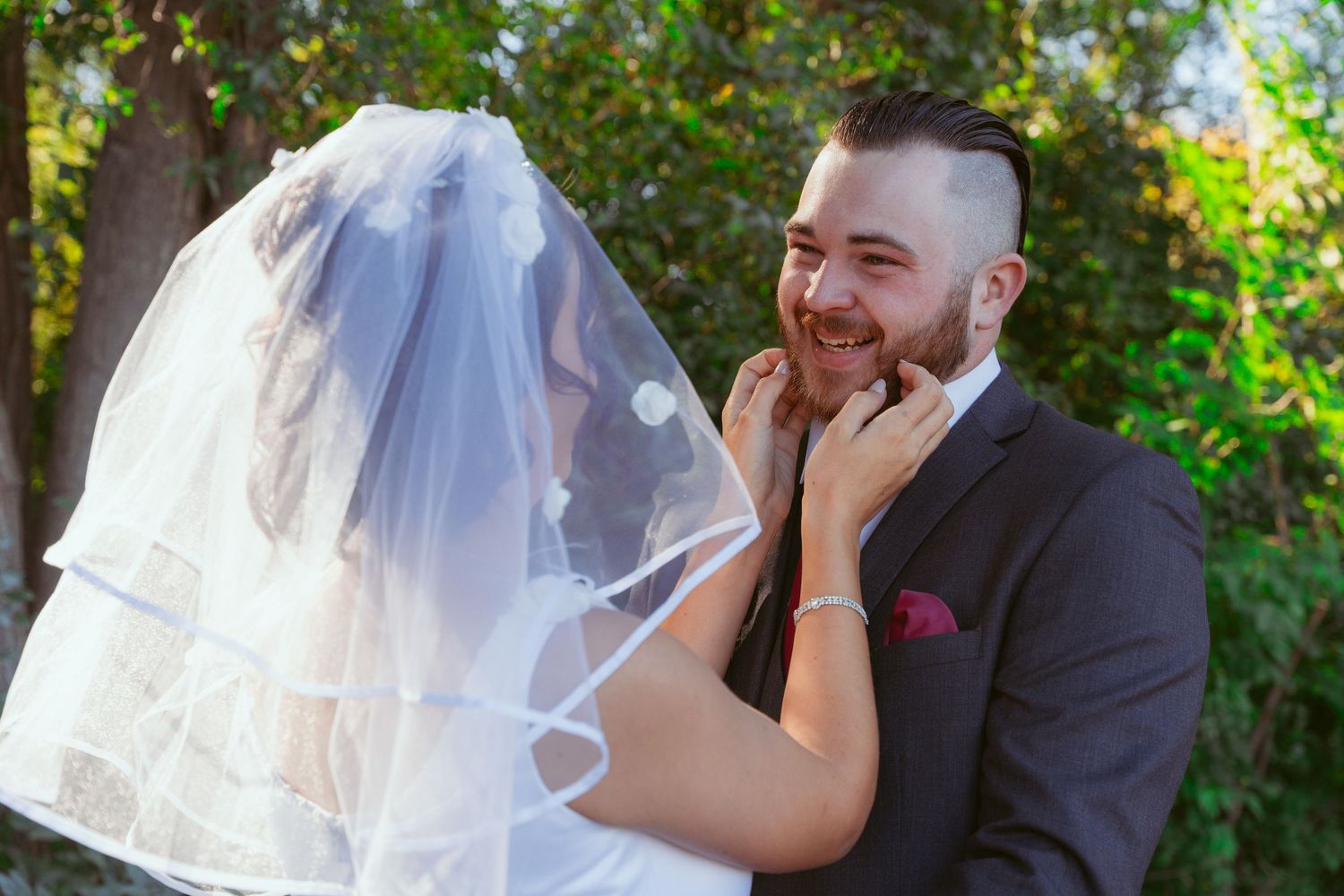 Joyful wedding couple sharing laughs during outdoor photo session.