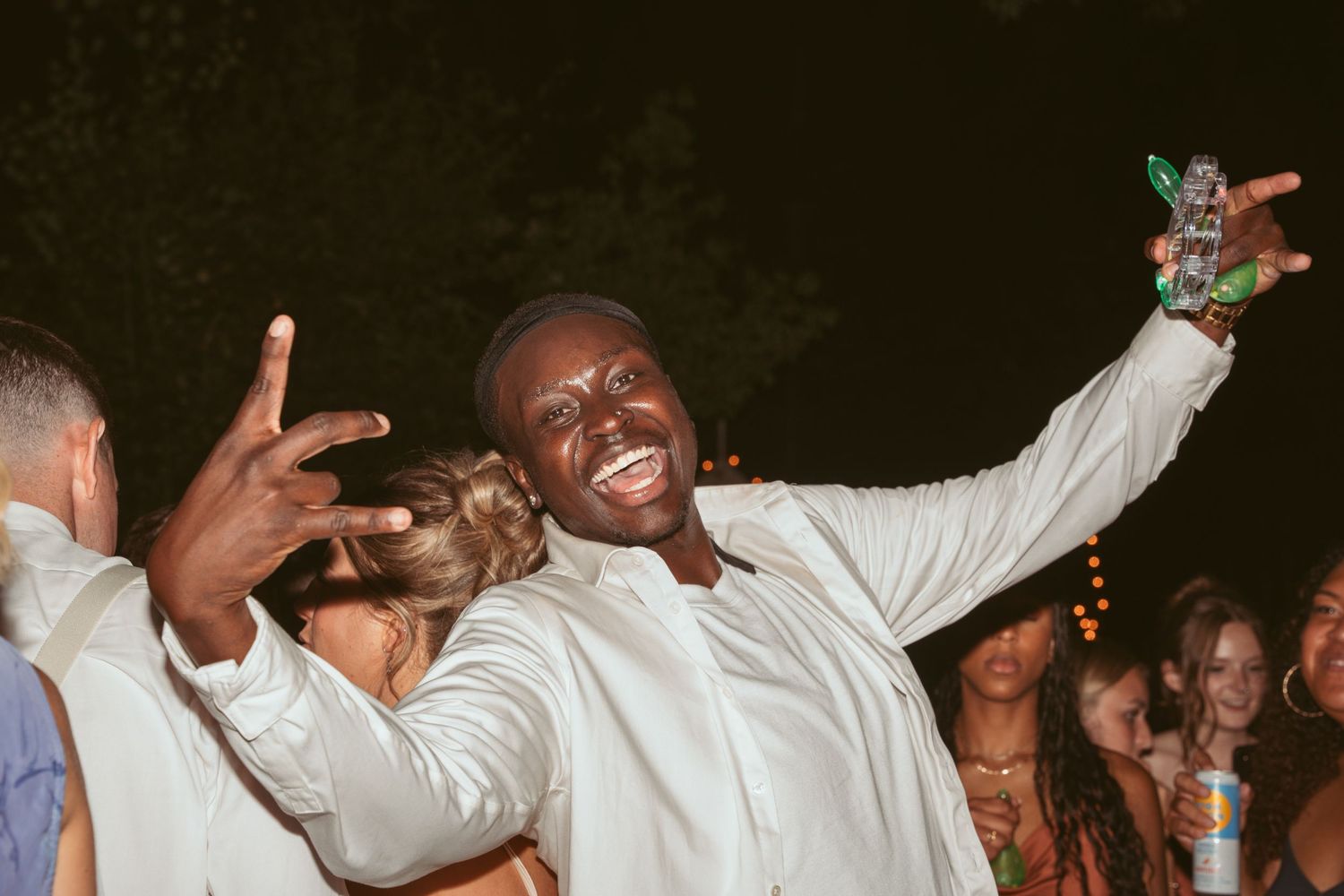 Joyful celebration with guests dancing and raising their hands on the dance floor.