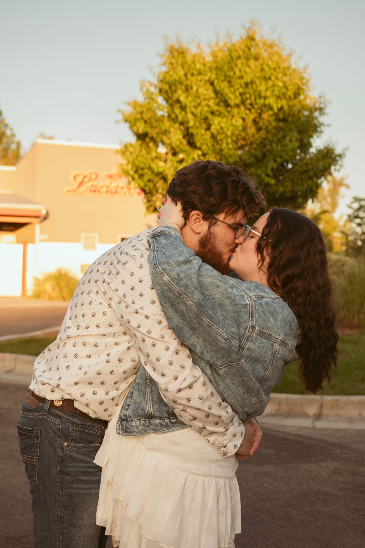 A romantic kiss shared during a golden hour proposal.