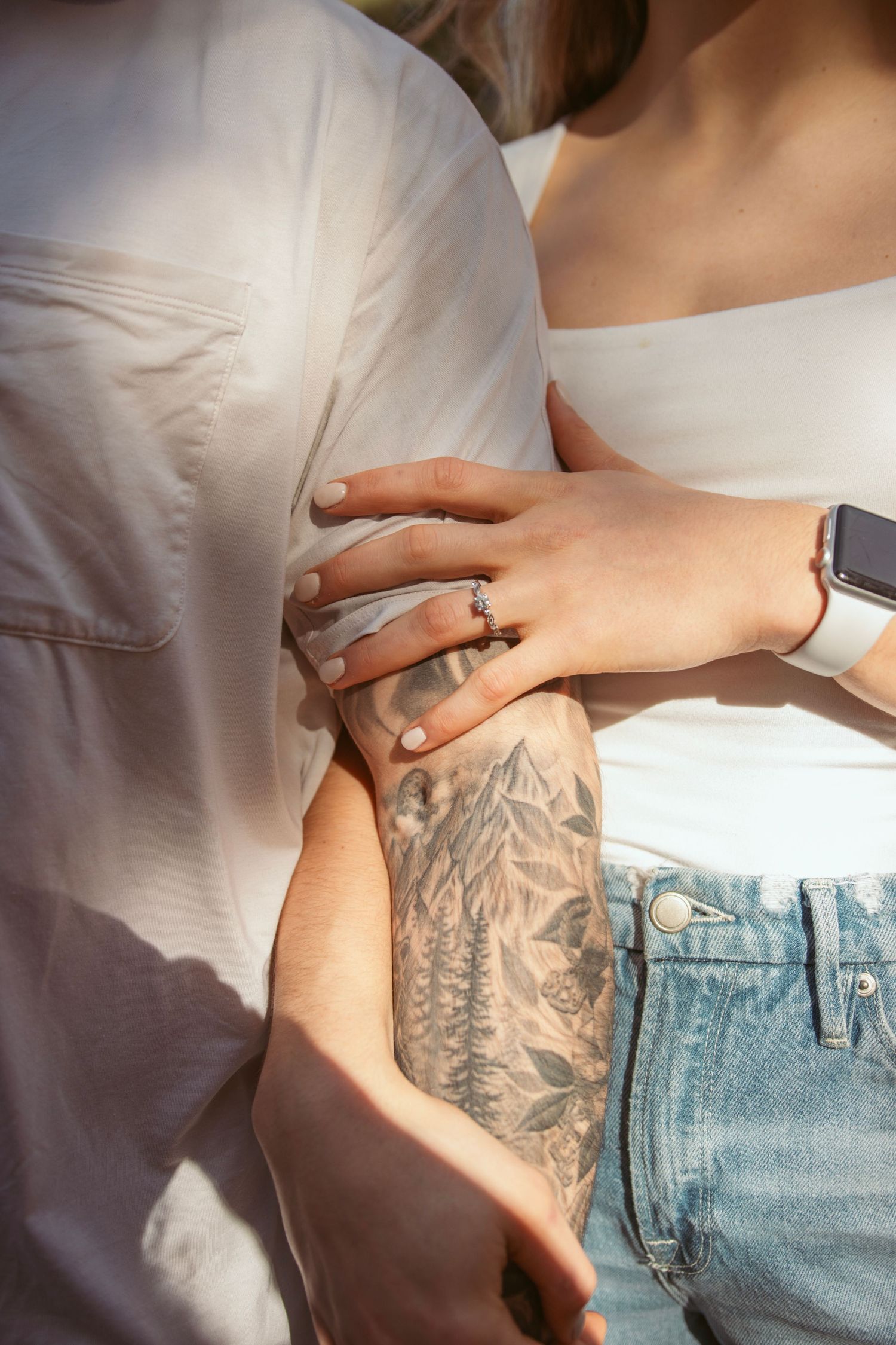 Close-up details of clothing and tattoo in natural lighting.