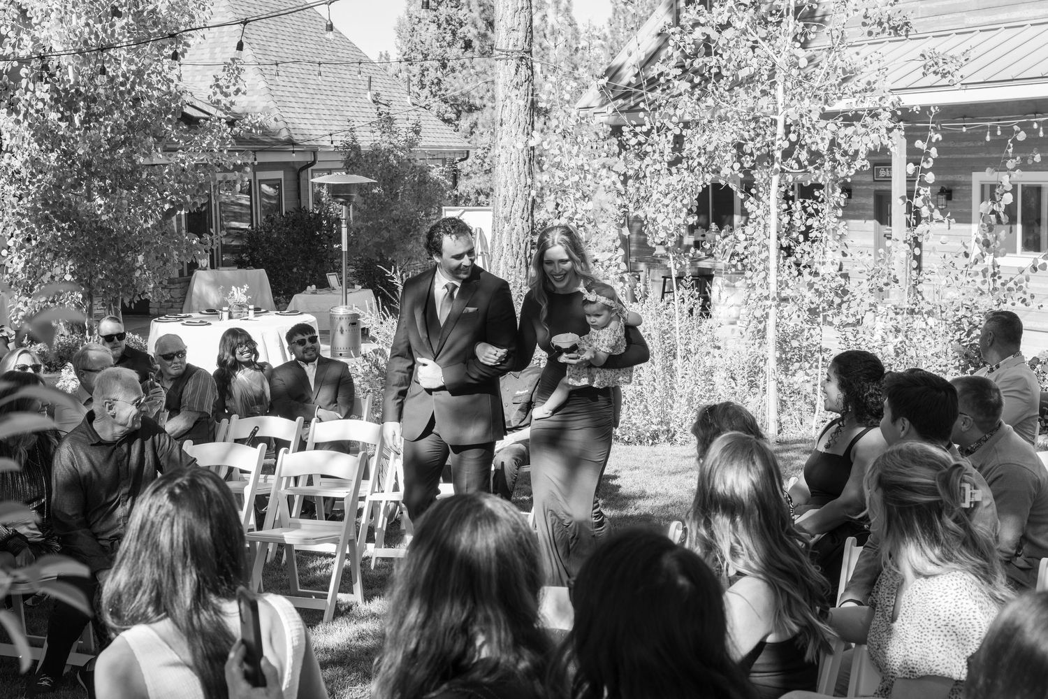 Black and white photo of wedding guests gathered for an outdoor ceremony.