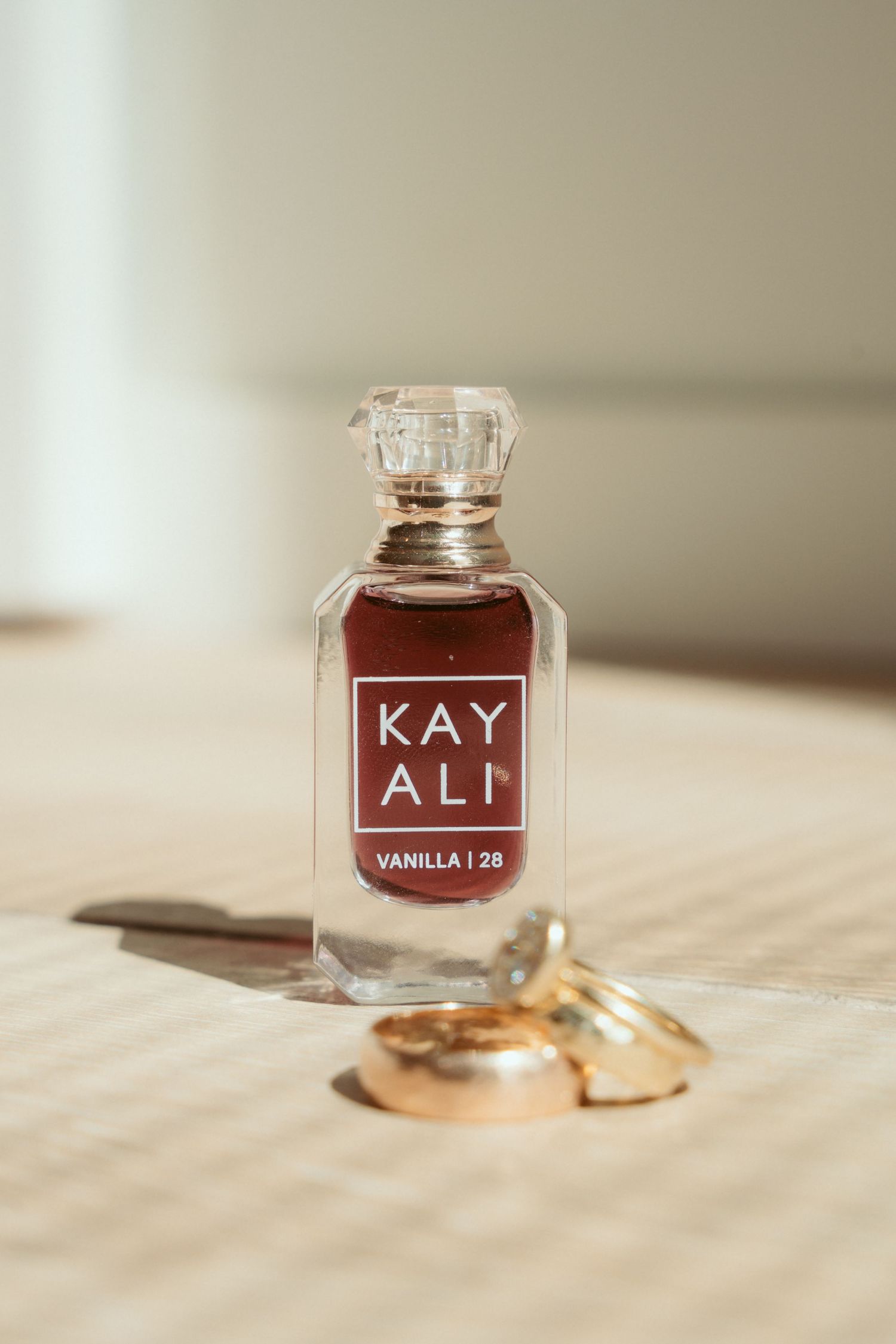 Glass perfume bottles with text labels displayed next to wedding rings.