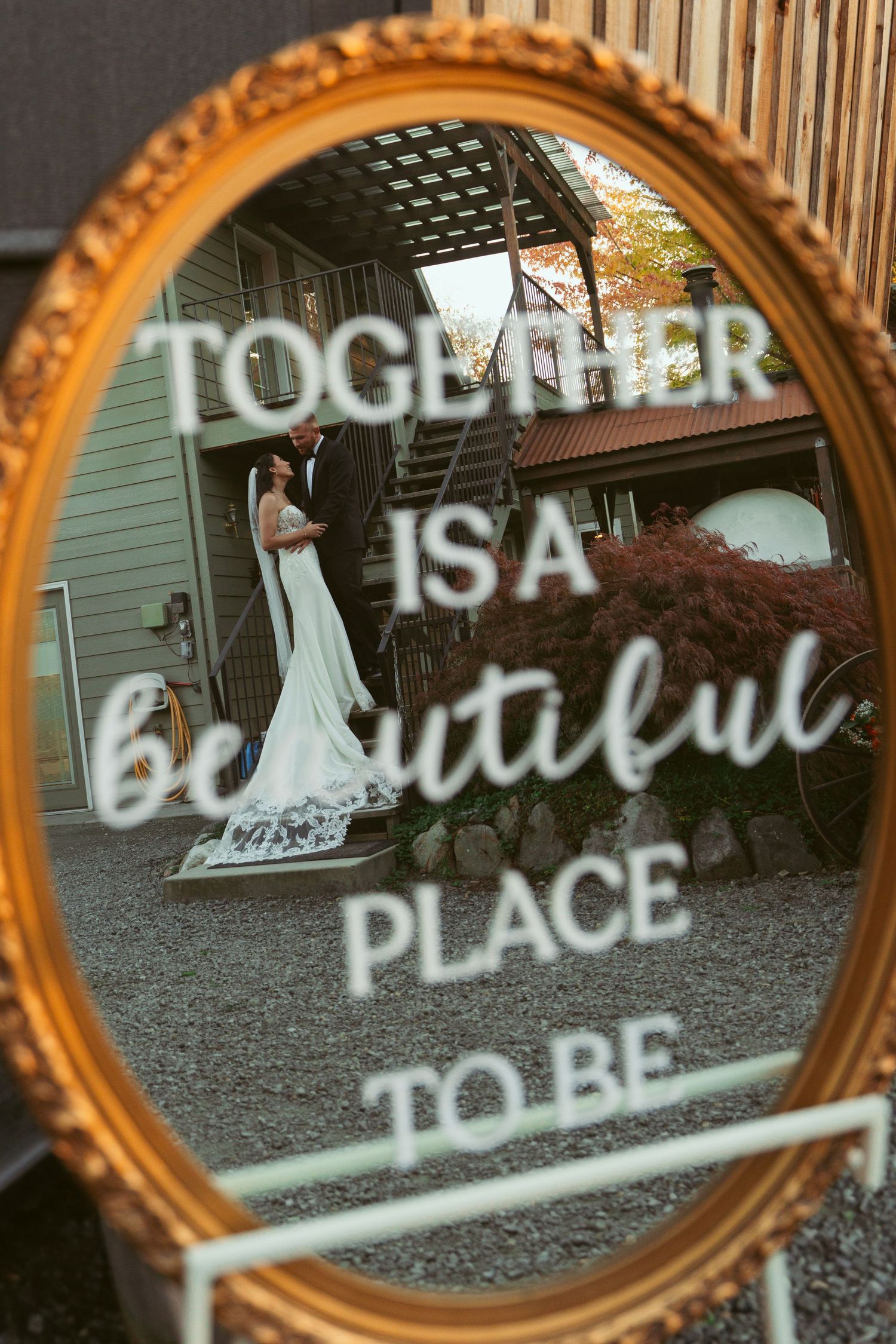Decorative gold mirror with romantic text reflections creates an artistic wedding detail.