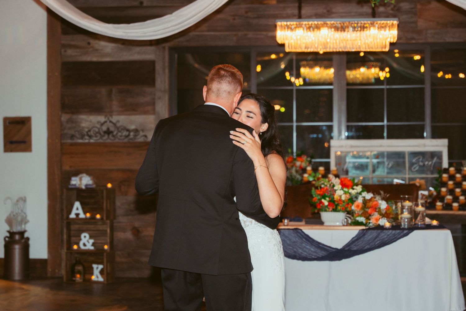 A tender moment between newlyweds during their wedding cake cutting ceremony in a rustic venue.