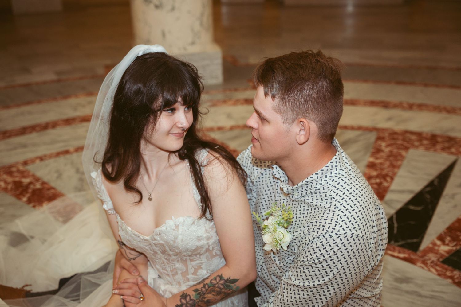 Couple dancing together on a patterned carpet in an elegant indoor setting.
